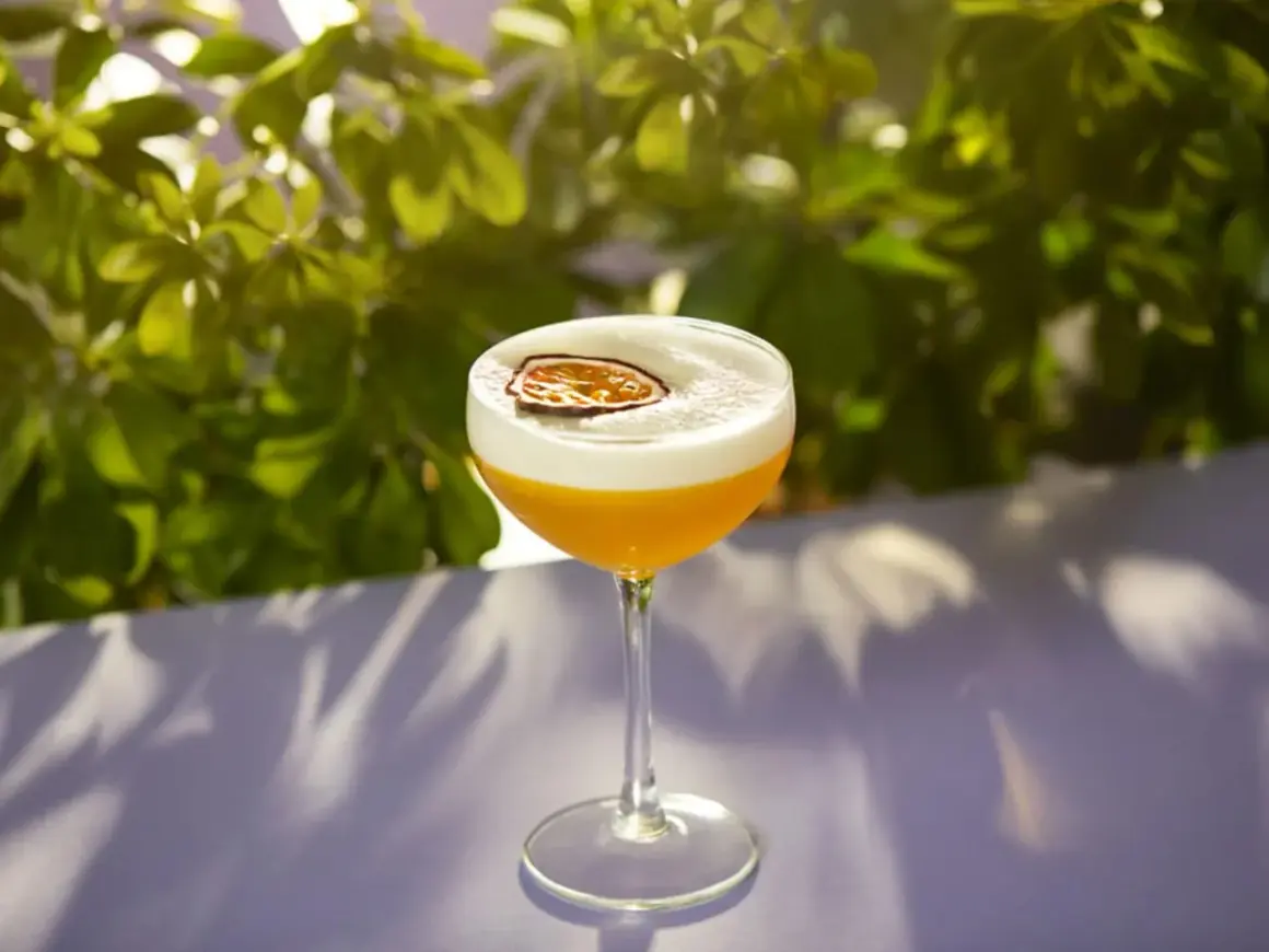 En läcker Pornstar Martini med passionsfrukt, toppad med skum och en torkad passionsfruktskiva.