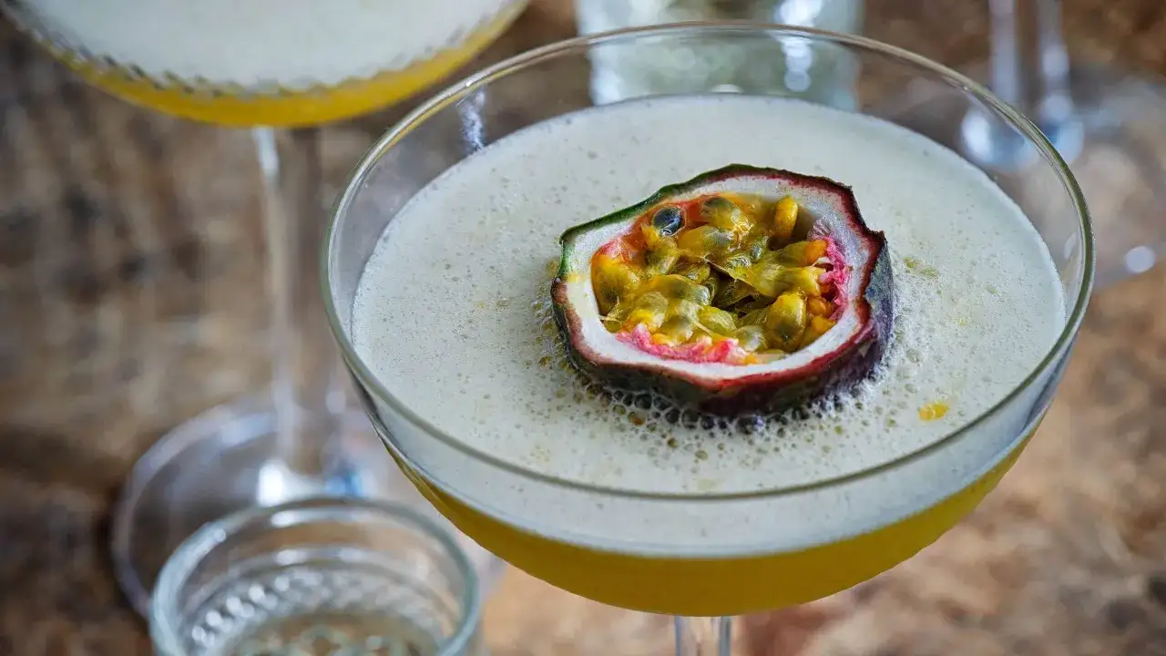 En Pornstar Martini med passionsfrukt som garnityr, skummig och inbjudande.